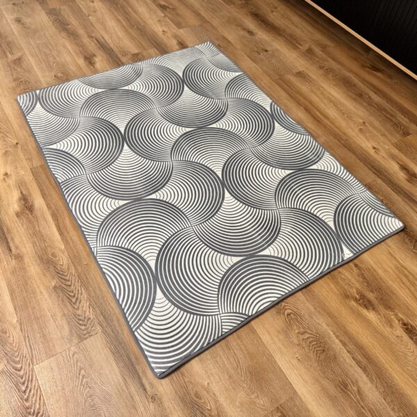 A soft, light gray foam rug with a modern pattern