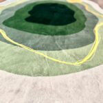 A soft green rug in an unusual shape