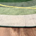 A soft green rug in an unusual shape