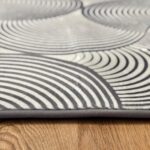 A soft, light gray foam rug with a modern pattern