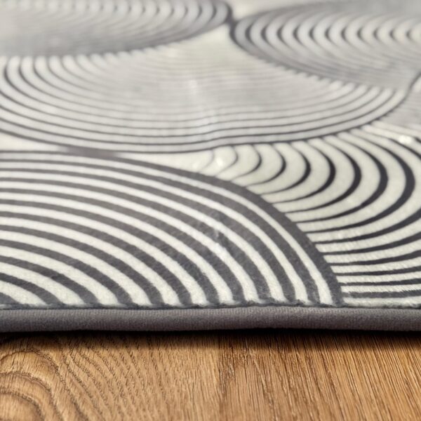 A soft, light gray foam rug with a modern pattern